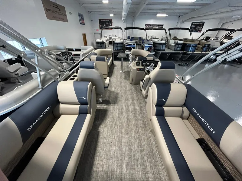 Slide: The Image of 2025 Bennington 22 SSR pontoon boat interior with beige and navy seating. - 18