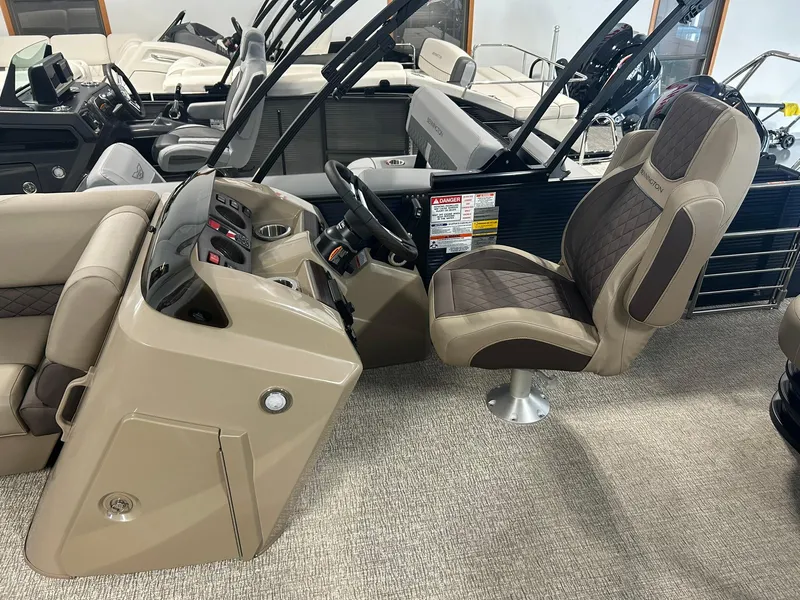 Slide: The Image of 2025 Bennington 22 SXSB boat interior with captain's chair and control console. - 8