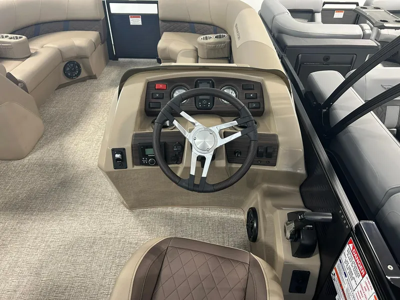 Slide: The Image of 2025 Bennington 22 SXSB boat interior with steering wheel and seating area. - 9