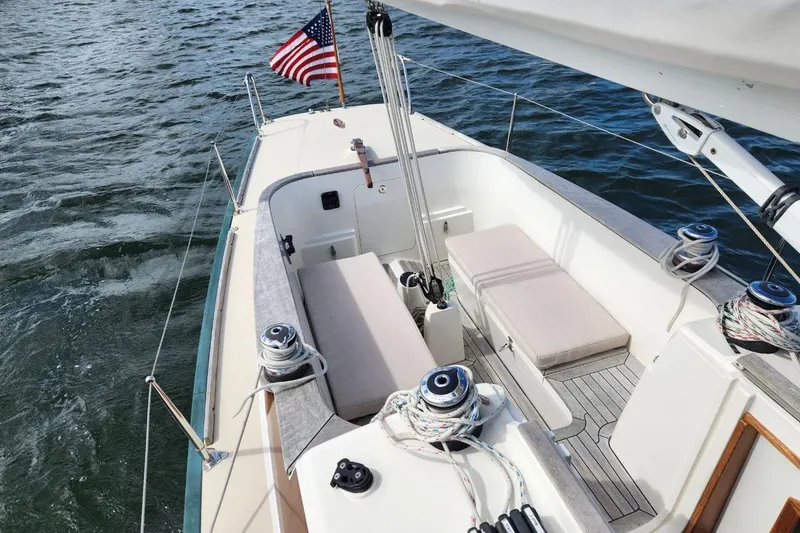 Slide: The Image of 2017 Rustler 33 sailboat cockpit with American flag on open water. - 2