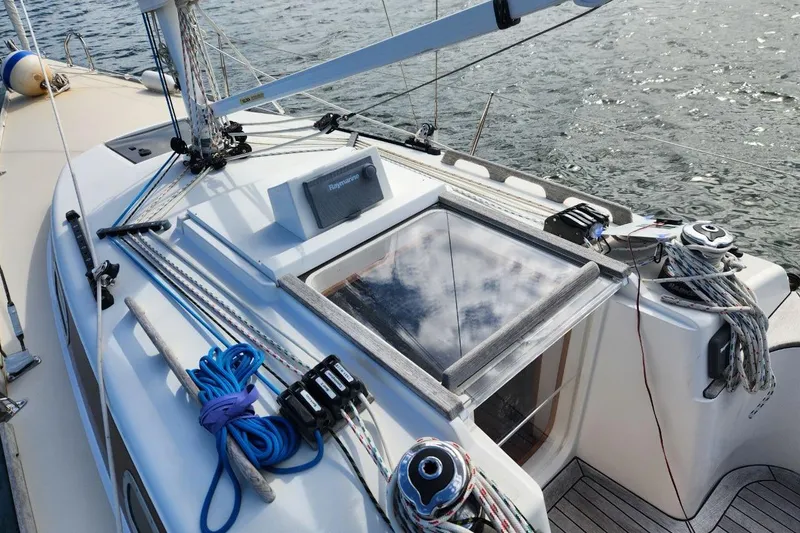 Slide: The Image of Sailboat deck of 2017 Rustler 33 with rigging and hatch, on calm water. - 3