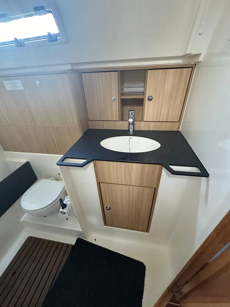 Slide: The Image of Bavaria 36 Cruiser 2011 bathroom with modern sink, wooden cabinetry, and compact toilet. - 17