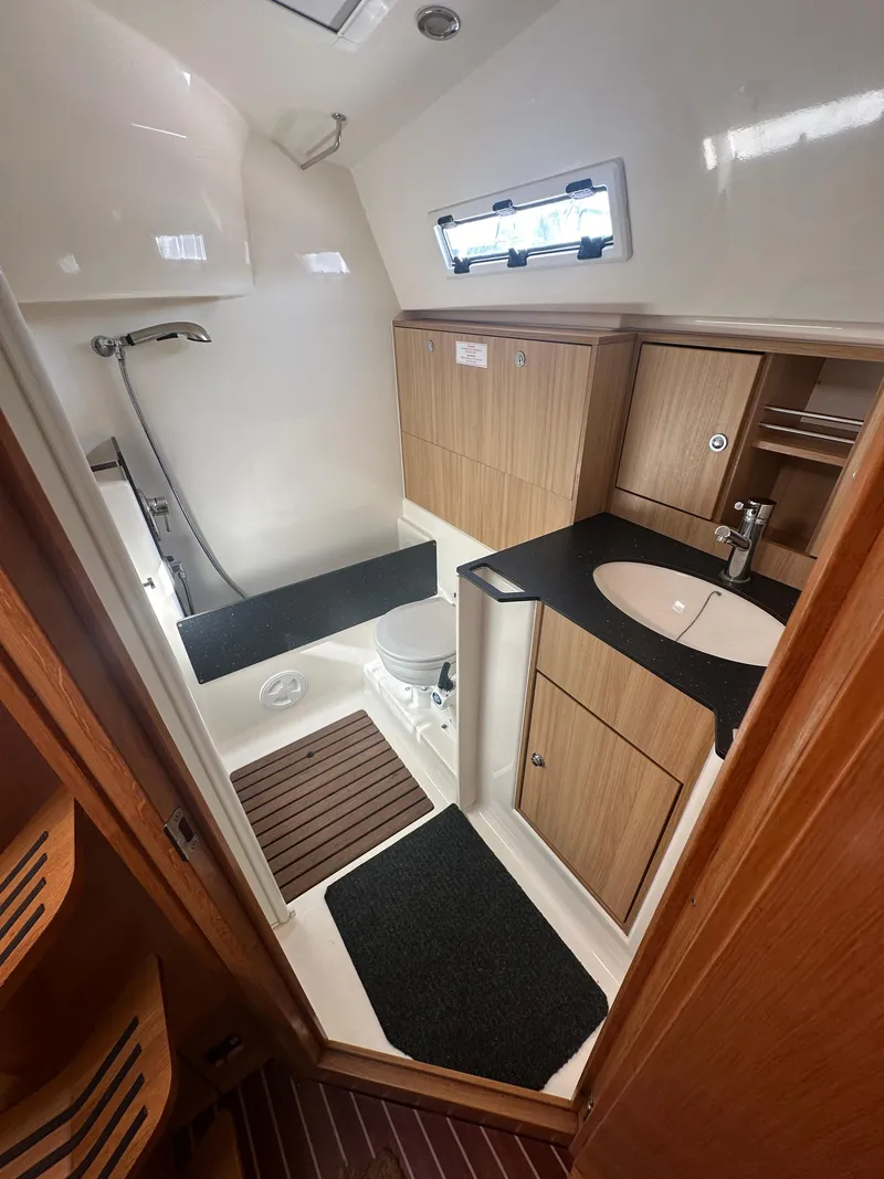 Slide: The Image of 2011 Bavaria 36 Cruiser bathroom with shower, sink, and wooden cabinetry. - 18
