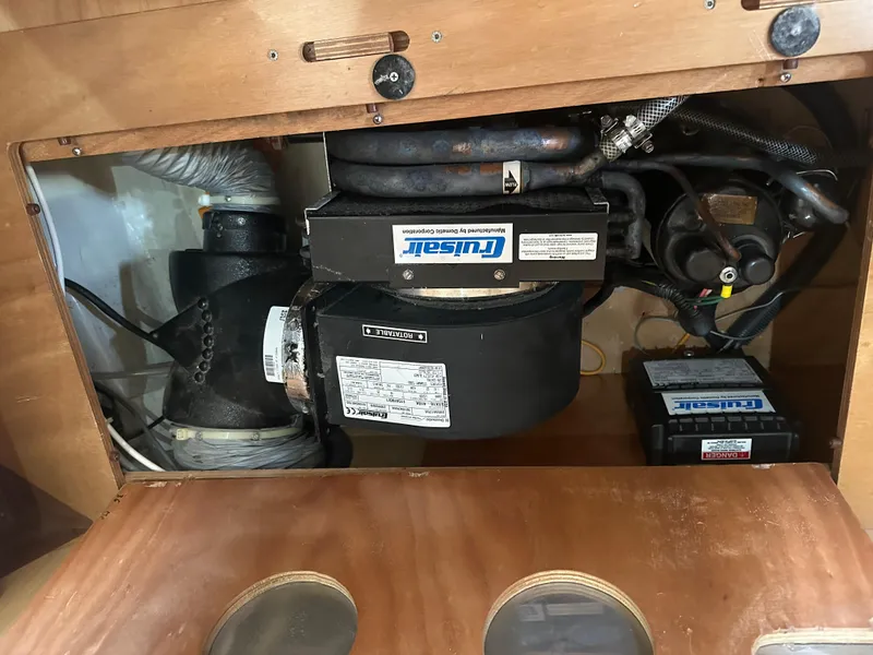 Slide: The Image of Engine compartment of a 2011 Bavaria 36 Cruiser sailboat, featuring mechanical components and wiring. - 24