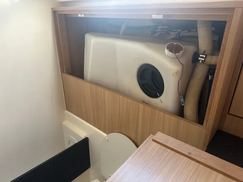 Slide: The Image of Bavaria 36 Cruiser 2011 interior showing a storage compartment with a water tank and plumbing. - 25