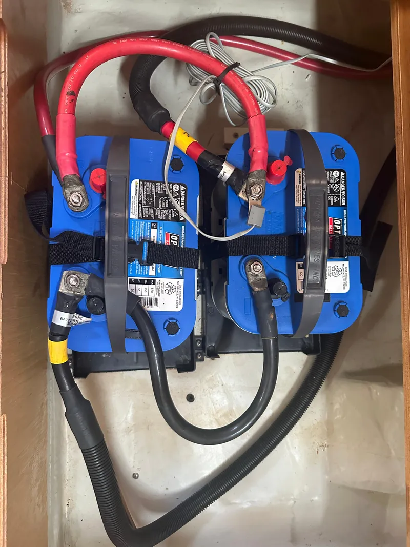 Slide: The Image of Two blue marine batteries with red and black cables in a Bavaria 36 Cruiser, 2011 model. - 30