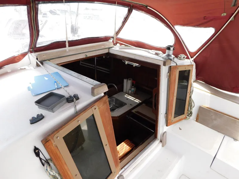 Slide: The Image of 1984 Endeavour 35.5 Sloop cockpit with open cabin doors and red canopy. - 30