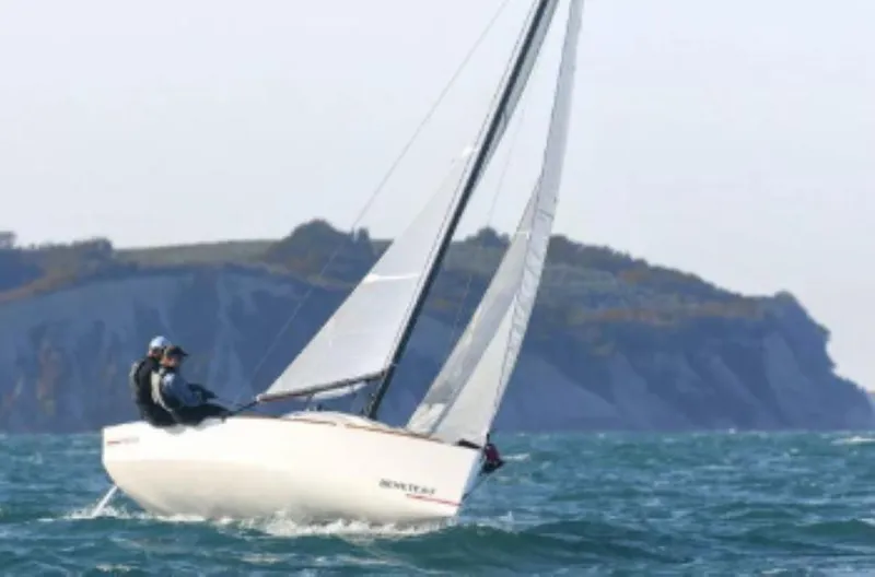 Slide: The Image of 2025 Beneteau First 18 SE sailing on open water with scenic cliffs in background. - 6