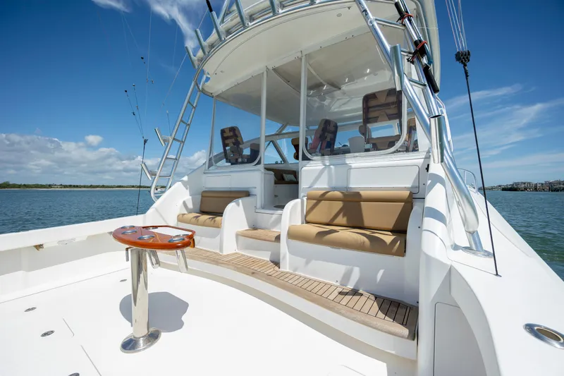 Slide: The Image of 2013 Viking 42 yacht with spacious deck and seating, under clear blue skies. - 13