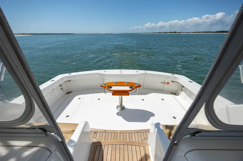 Slide: The Image of 2013 Viking 42 yacht deck with ocean view, featuring a central table and clear skies. - 14
