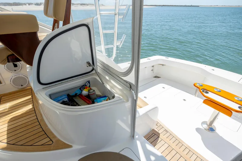 Slide: The Image of 2013 Viking 42 yacht deck with open storage compartment, overlooking serene water. - 22