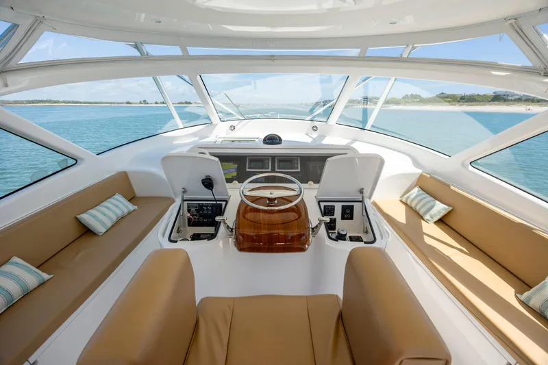 Slide: The Image of Luxurious 2013 Viking 42 yacht interior with tan seating and panoramic windows. - 25