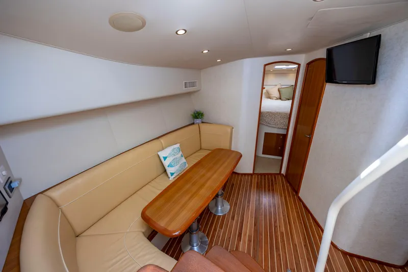 Slide: The Image of 2013 Viking 42 yacht interior with dining area, wooden flooring, and cozy seating. - 39
