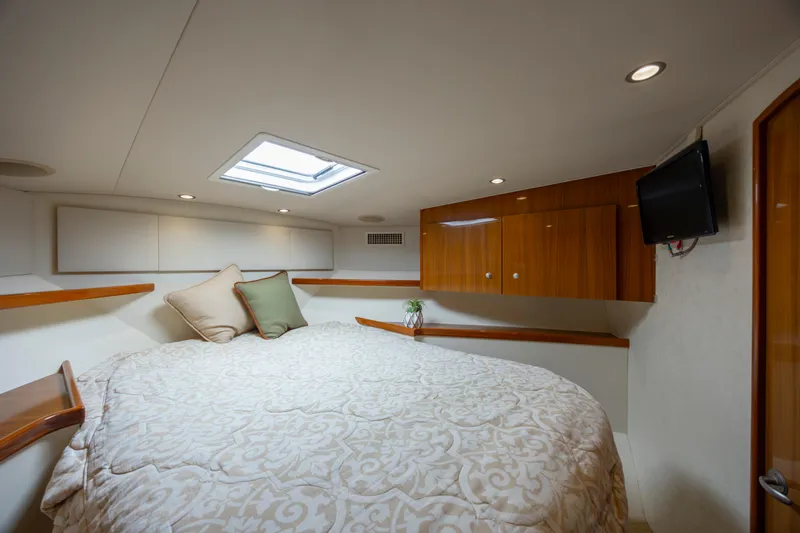Slide: The Image of Luxurious cabin interior of 2013 Viking 42 yacht with cozy bedding and wooden cabinetry. - 44