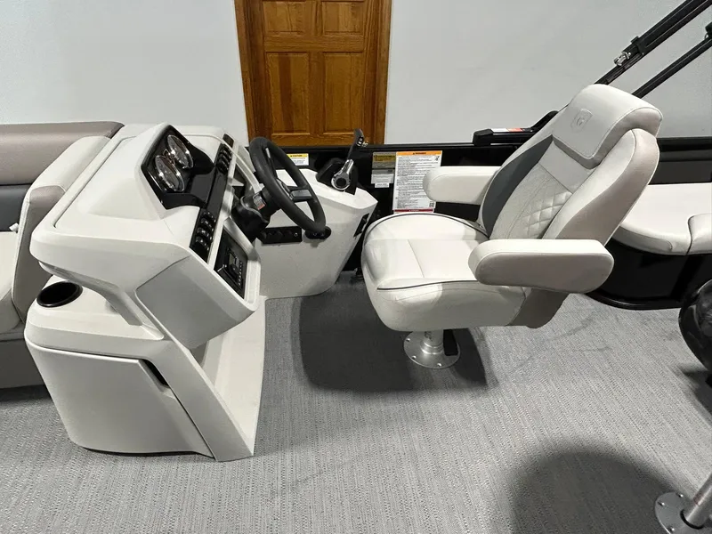 Slide: The Image of 2025 Godfrey SWEETWATER 2286 SFL boat interior with captain's chair and steering console. - 8