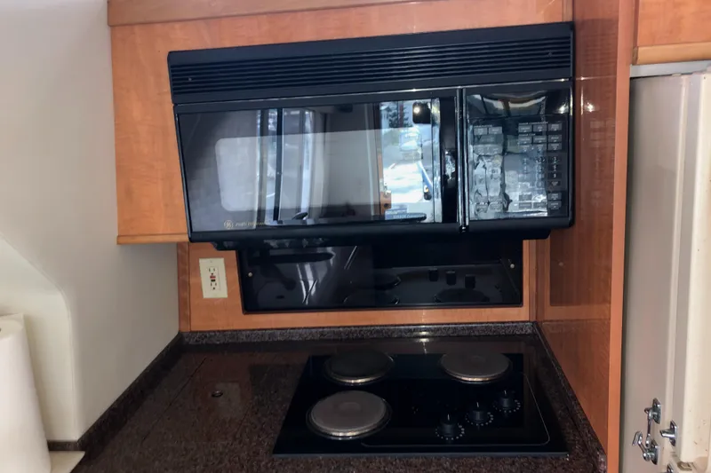Slide: The Image of Kitchen area in 2002 Bayliner 5288 PILOTHOUSE with microwave and stovetop. - 19