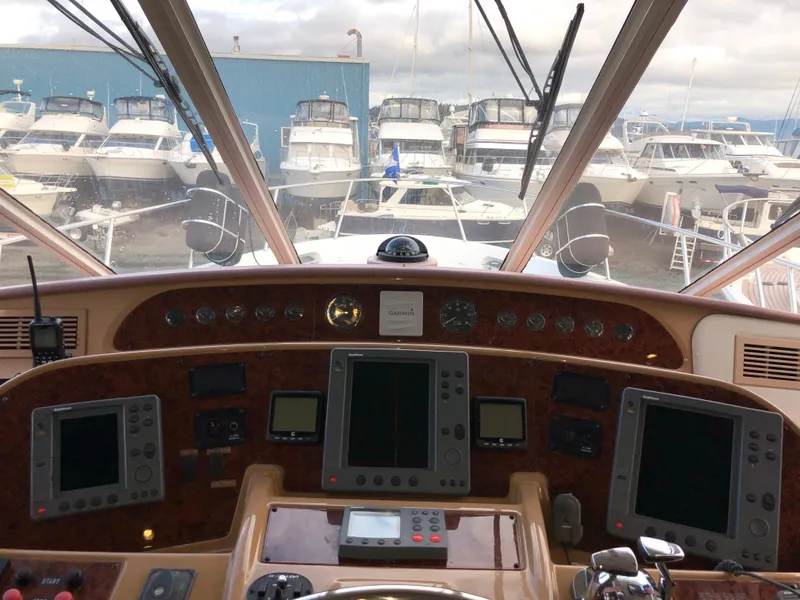 Slide: The Image of Pilothouse view of 2002 Bayliner 5288, featuring navigation instruments and marina backdrop. - 21