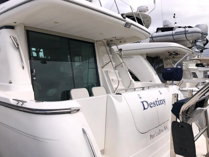 Slide: The Image of 2002 Bayliner 5288 Pilothouse yacht docked, featuring sleek white exterior and modern design. - 3