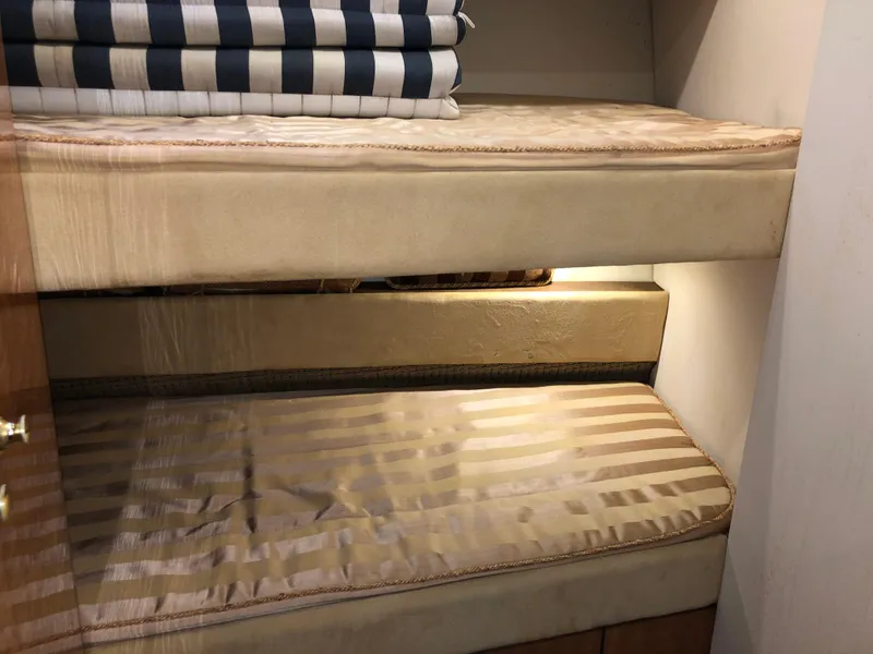 Slide: The Image of 2002 Bayliner 5288 PILOTHOUSE interior with striped bunk beds and cozy lighting. - 36