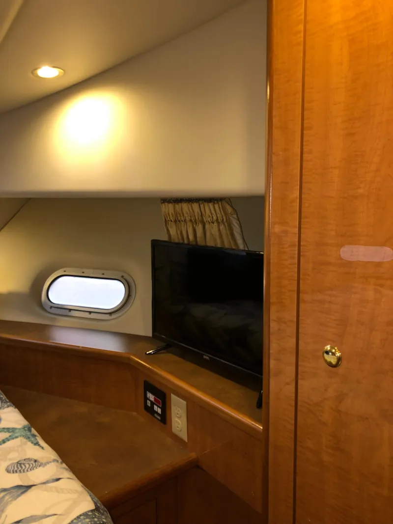 Slide: The Image of Interior of 2002 Bayliner 5288 PILOTHOUSE with TV, porthole, and wooden cabinetry. - 41