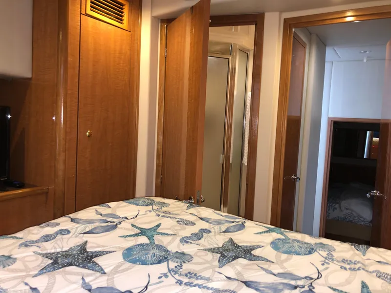 Slide: The Image of Interior of 2002 Bayliner 5288 PILOTHOUSE with nautical-themed bedding and wooden cabinetry. - 43