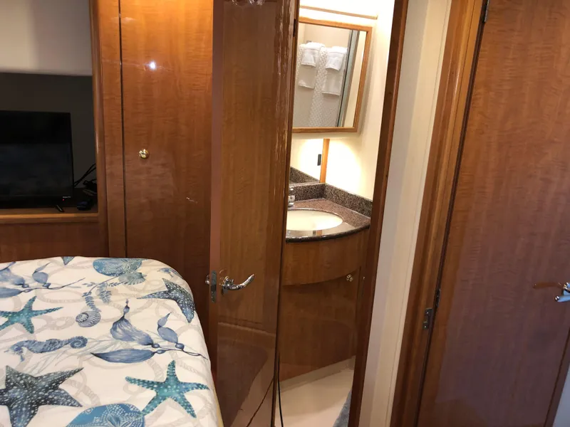 Slide: The Image of Luxurious 2002 Bayliner 5288 PILOTHOUSE cabin with ensuite bathroom and nautical-themed bedding. - 44