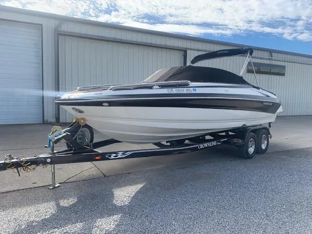 Slide: The Image of 2007 Crownline 230 LS boat on trailer, parked outside a warehouse. - 2