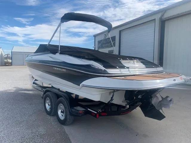 Slide: The Image of 2007 Crownline 230 LS boat on trailer, parked outdoors under a blue sky. - 4