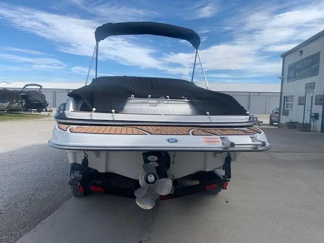 Slide: The Image of 2007 Crownline 230 LS boat with covered deck and visible propeller, parked outdoors. - 5