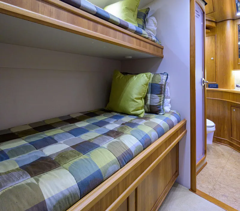 Slide: The Image of Bunk beds in 2011 Paul Mann Custom 81 Convertible yacht cabin, featuring colorful checkered bedding. - 41