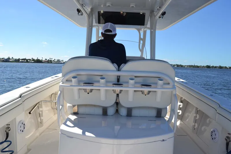 Slide: The Image of 2012 Jupiter 34 FS boat on water, rear view with person seated, clear sky. - 22
