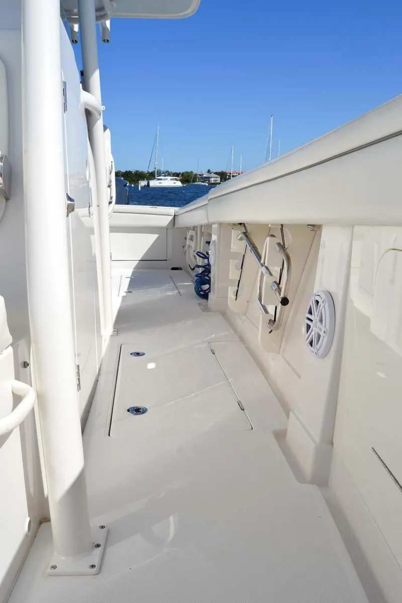 Slide: The Image of 2012 Jupiter 34 FS boat deck with storage and speakers, under clear blue sky. - 24