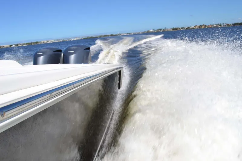 Slide: The Image of Jupiter 34 FS boat speeding on water, creating a large wake, under clear blue skies. - 42