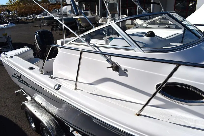 Slide: The Image of 2016 Pro-Line 20 Express boat, sleek white design, docked on a trailer. - 14