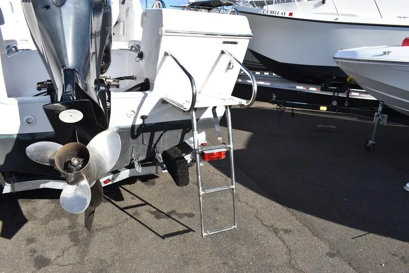 Slide: The Image of 2016 Pro-Line 20 Express boat with ladder and outboard motor, docked on pavement. - 24
