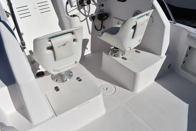 Slide: The Image of 2016 Pro-Line 20 Express boat interior with dual white captain chairs and steering wheel. - 36