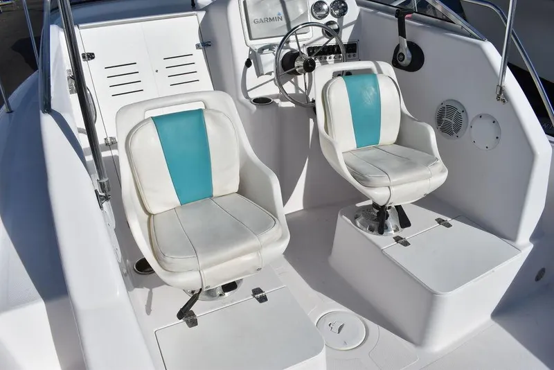 Slide: The Image of 2016 Pro-Line 20 Express boat interior with white and teal seating, steering wheel, and dashboard. - 39