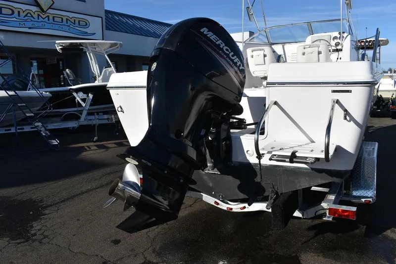 Slide: The Image of 2016 Pro-Line 20 Express boat with Mercury outboard motor, parked at a marina. - 6