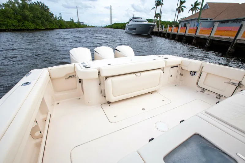 Slide: The Image of 2016 Grady-White 376 Canyon boat interior with triple engines on a scenic waterway. - 8
