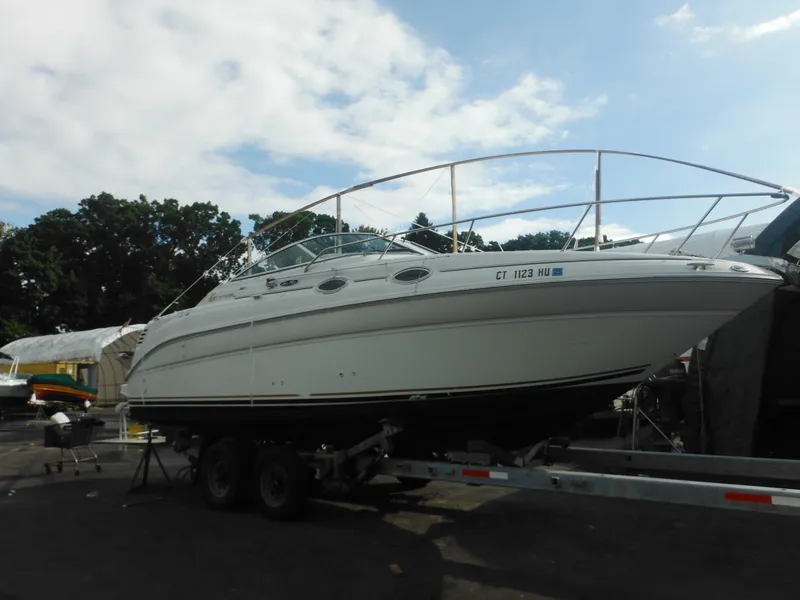 Slide: The Image of 2002 Sea Ray 260 Sundancer boat on trailer, parked outdoors. - 10