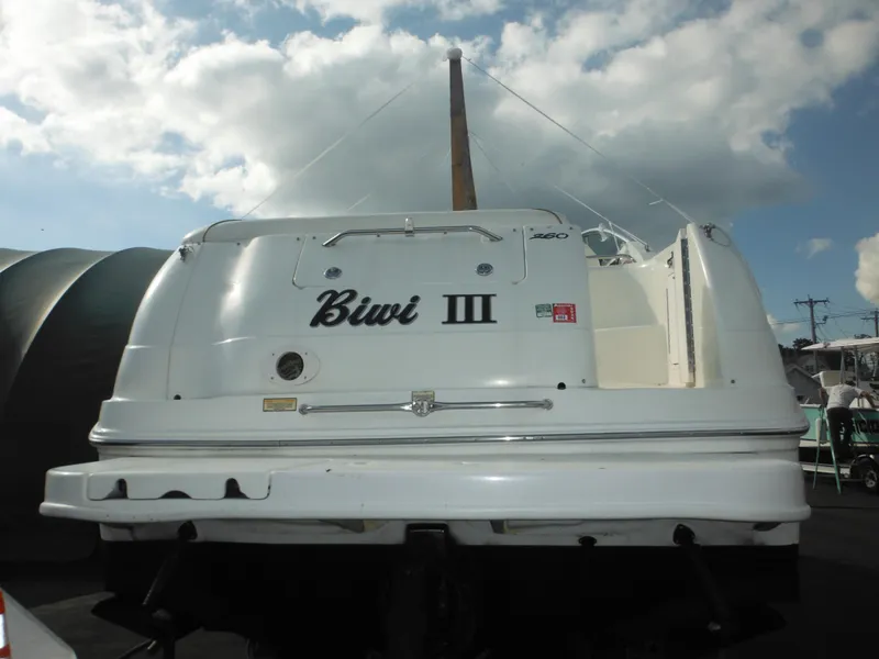 Slide: The Image of 2002 Sea Ray 260 Sundancer boat, rear view, named "Biwi III" under cloudy sky. - 15