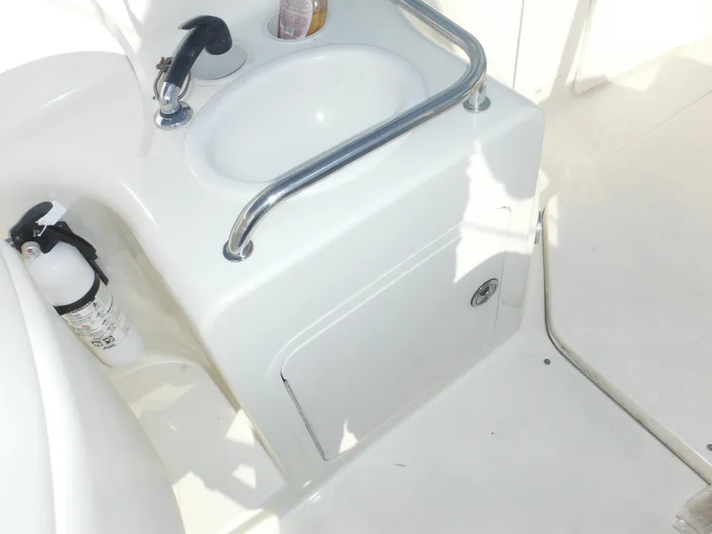 Slide: The Image of 2002 Sea Ray 260 Sundancer boat sink and fire extinguisher in cockpit area. - 24