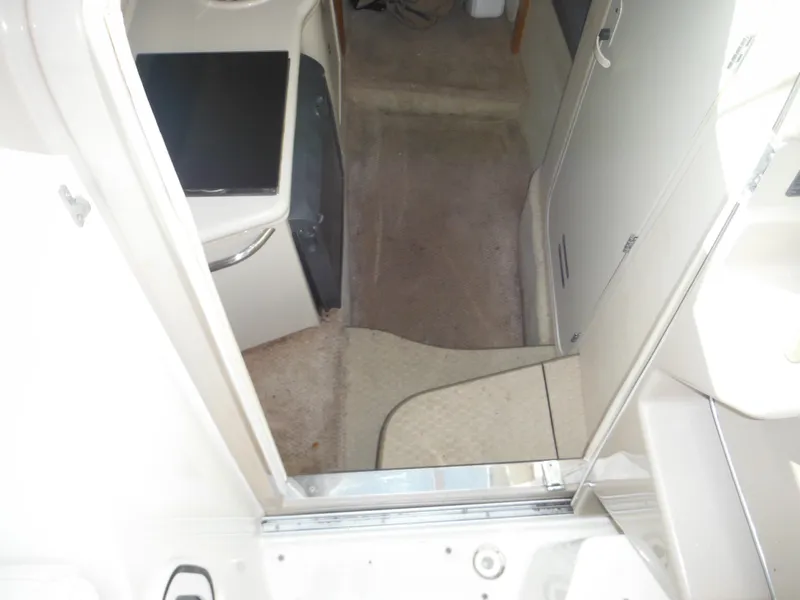 Slide: The Image of Interior view of 2002 Sea Ray 260 Sundancer cabin with beige carpet and compact layout. - 43