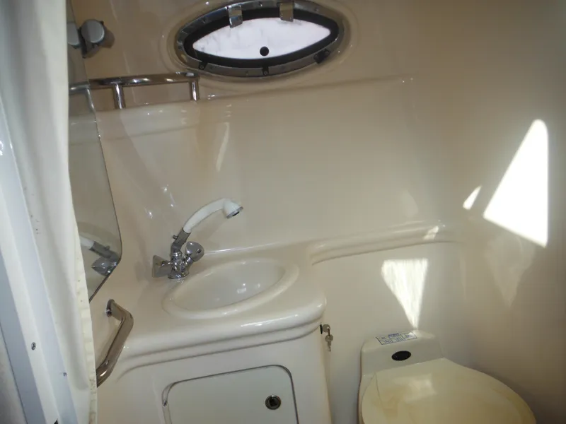 Slide: The Image of Compact bathroom in 2002 Sea Ray 260 Sundancer boat with sink and toilet. - 49