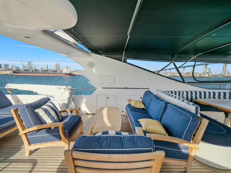 Slide: The Image of Luxurious 2011 President Sterling yacht deck with blue cushioned seating, overlooking a bustling harbor. - 16