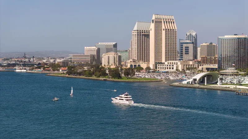 Slide: The Image of Yacht cruising in San Diego Bay with city skyline in the background. - 4