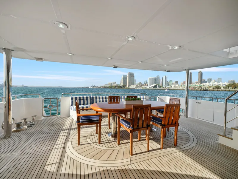 Slide: The Image of Spacious yacht deck with wooden dining set, ocean view, and city skyline. President Sterling 2011. - 5