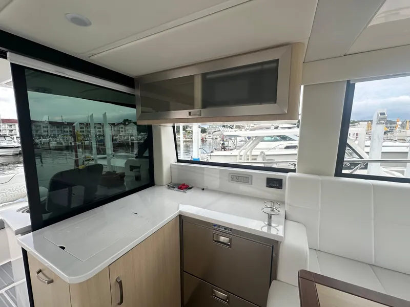 Slide: The Image of Interior of 2025 Regal 38 Grande Coupe yacht with modern kitchen and marina view. - 3