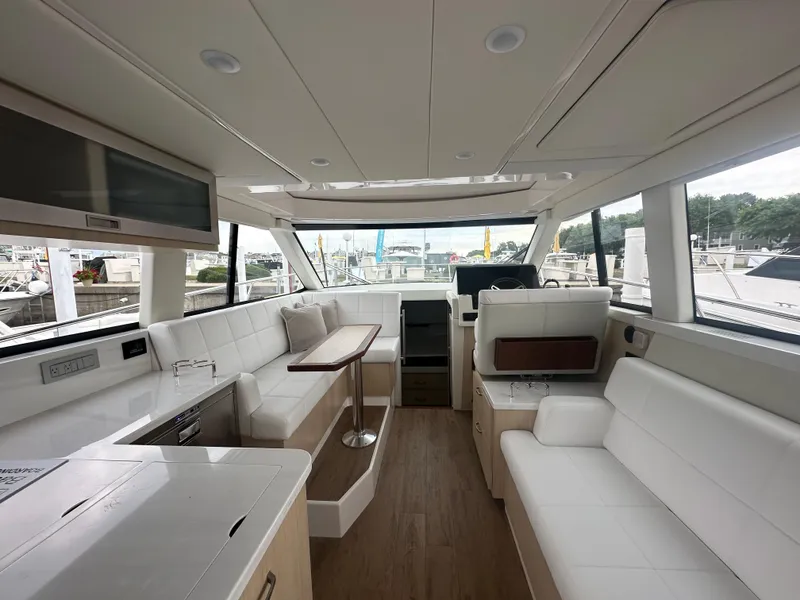 Slide: The Image of Luxurious interior of 2025 Regal 38 Grande Coupe yacht with modern seating and panoramic windows. - 4