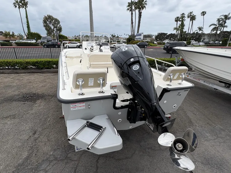 Slide: The Image of 2025 Boston Whaler 190 Montauk boat with outboard motor, parked on a lot. - 3